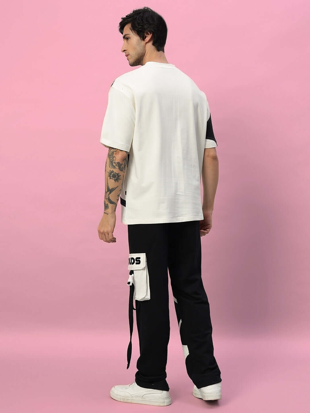 Man wearing DAVID JOGGER in black by DUDS, showcasing custom fit option against pink background for tailored fashion.