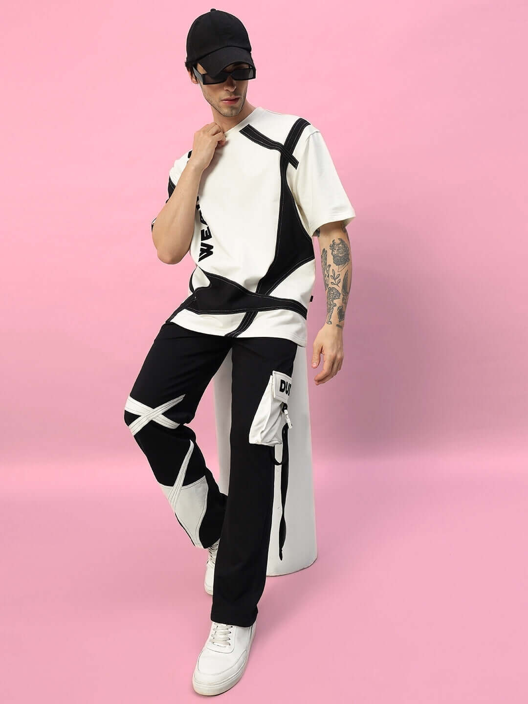Fashion model wearing DAVID DESIGNER OVERSIZED T-SHIRT OFF WHITE BLACK, showcasing modern and stylish oversized fit on a pink background.