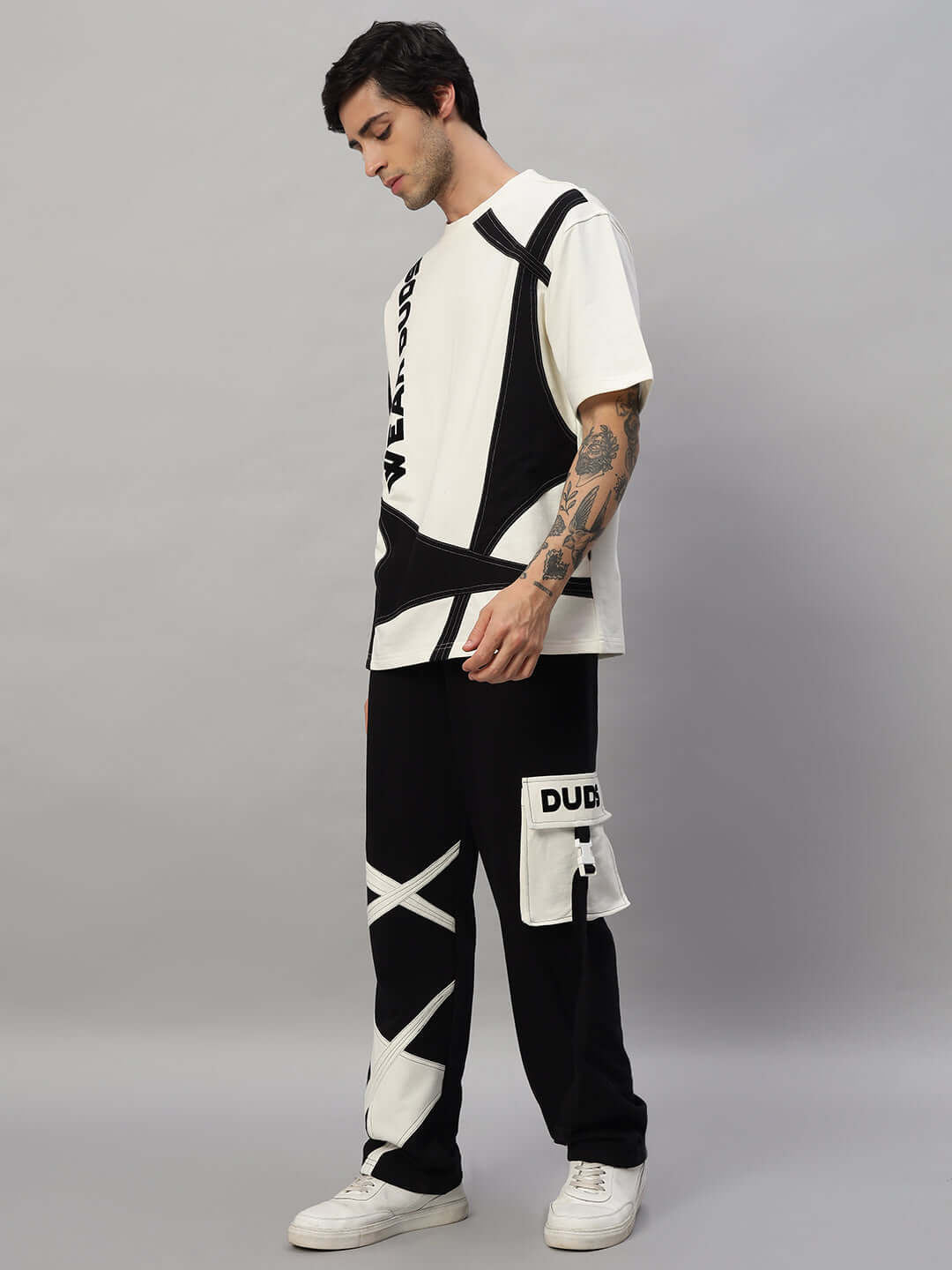 Model wearing DAVID oversized co-ord set in off white and black, featuring unisex relaxed fit joggers with elasticated waistband and drawstring.