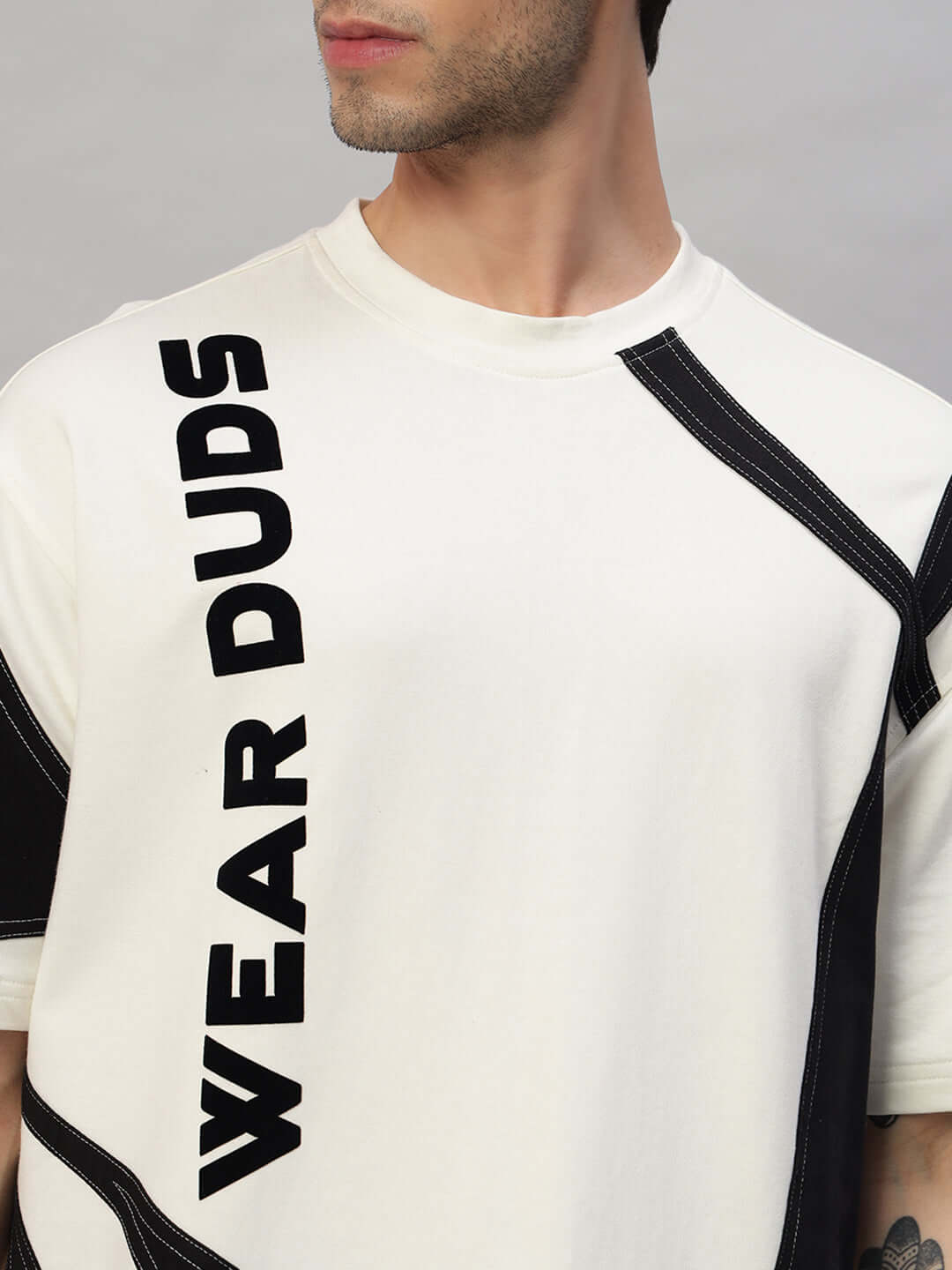 Close-up of a model wearing the DAVID Oversized Co-Ord Set in off white-black with 'WEAR DUDS' text, showcasing relaxed fit and stylish design.