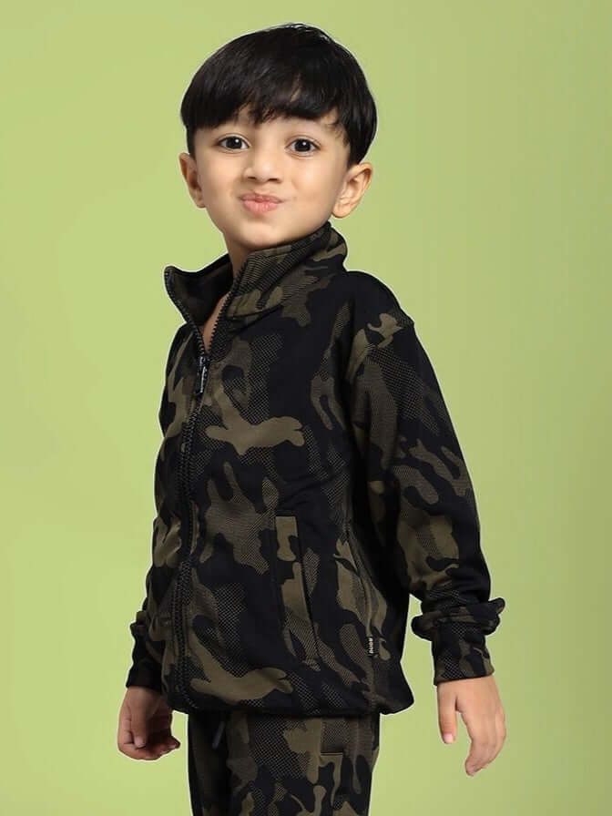 Child wearing DEFENCE CAMOFLAUGE JACKET FOR BOYS AND GIRLS CAMO GREEN, showcasing stylish camo pattern against a green backdrop.