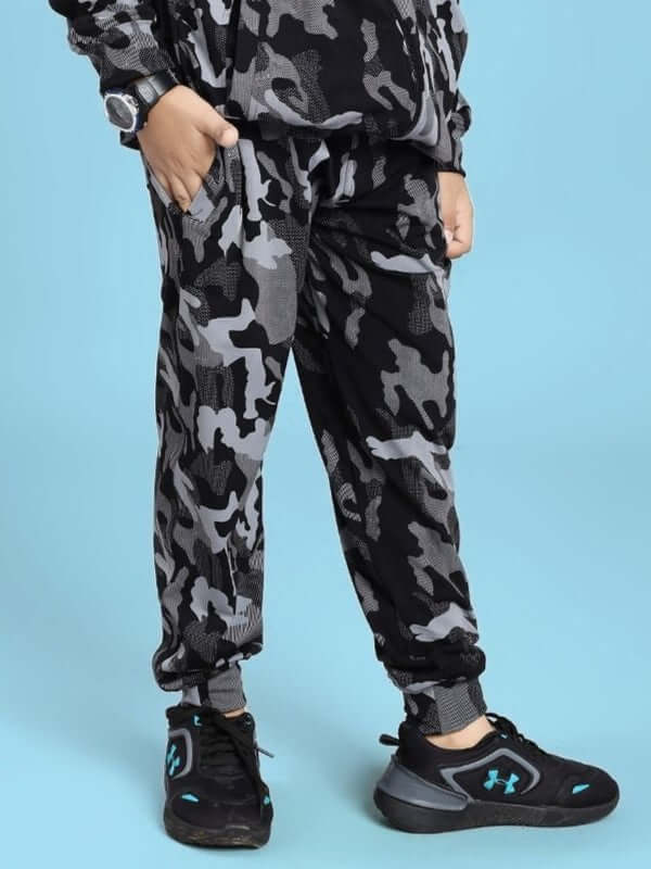 DEFENCE JOGGER FOR BOYS AND GIRLS BLACK GREY camouflage pants displayed on a child wearing black sneakers.