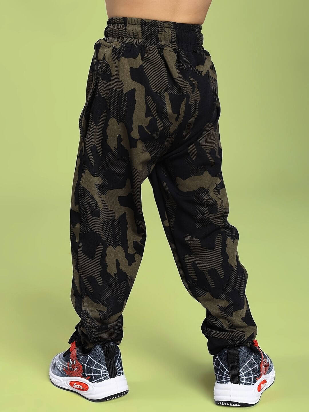 Child wearing DEFENCE JOGGER FOR BOYS AND GIRLS CAMO GREEN showcasing camouflage design and comfortable fit.