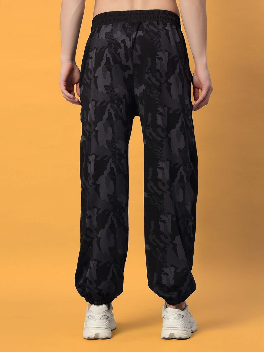 Back view of navy camo relaxed jogger pants, tailored for comfort with elastic waist, shown with white sneakers.