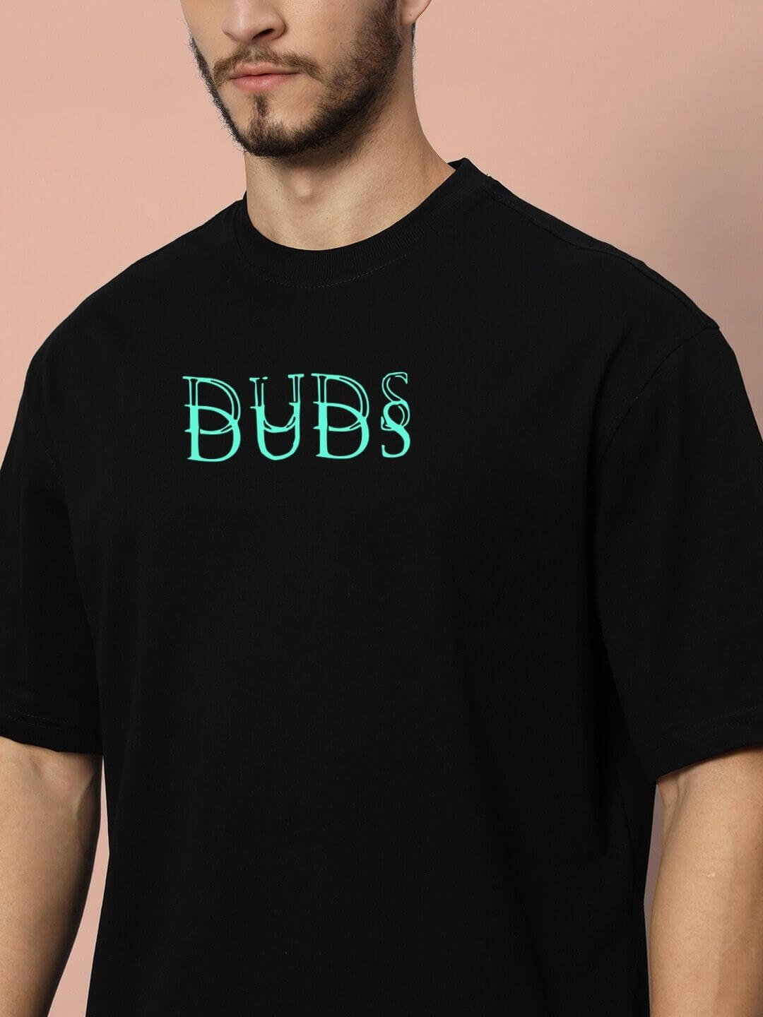 Model wearing DELUSION OVER-SIZED T-SHIRT BLACK with DUBS logo, showcasing street style and minimalist edge.