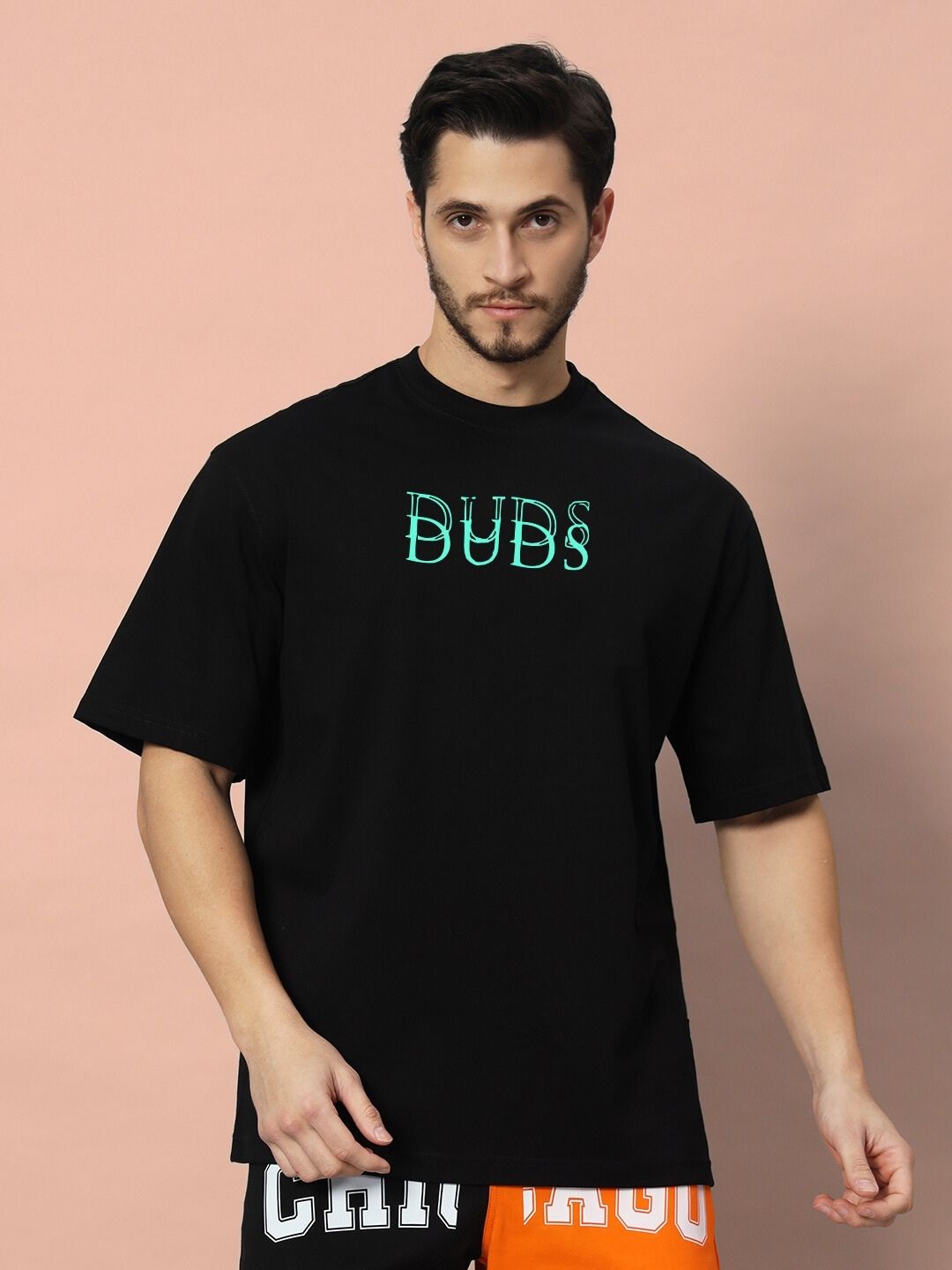 Model wearing DELUSION OVER-SIZED T-SHIRT BLACK with logo design on front in casual style.