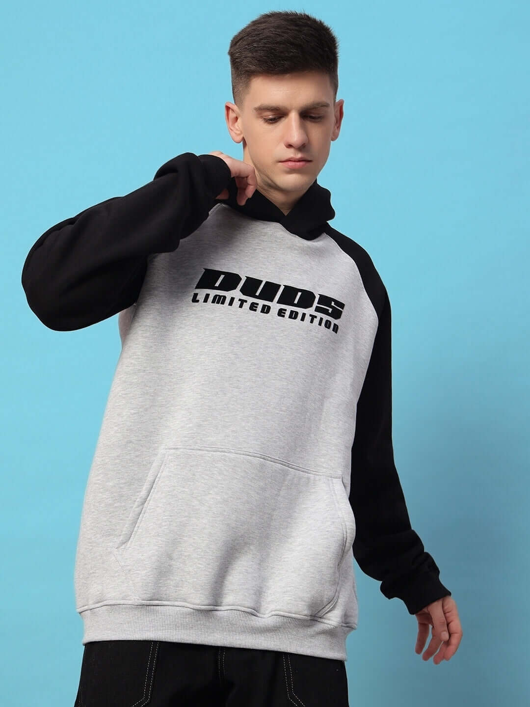 Man wearing DELUXE FLEECE COLORBLOCK OVERSIZE HOODIE BLACK MELANGE GREY showcasing streetwear fashion