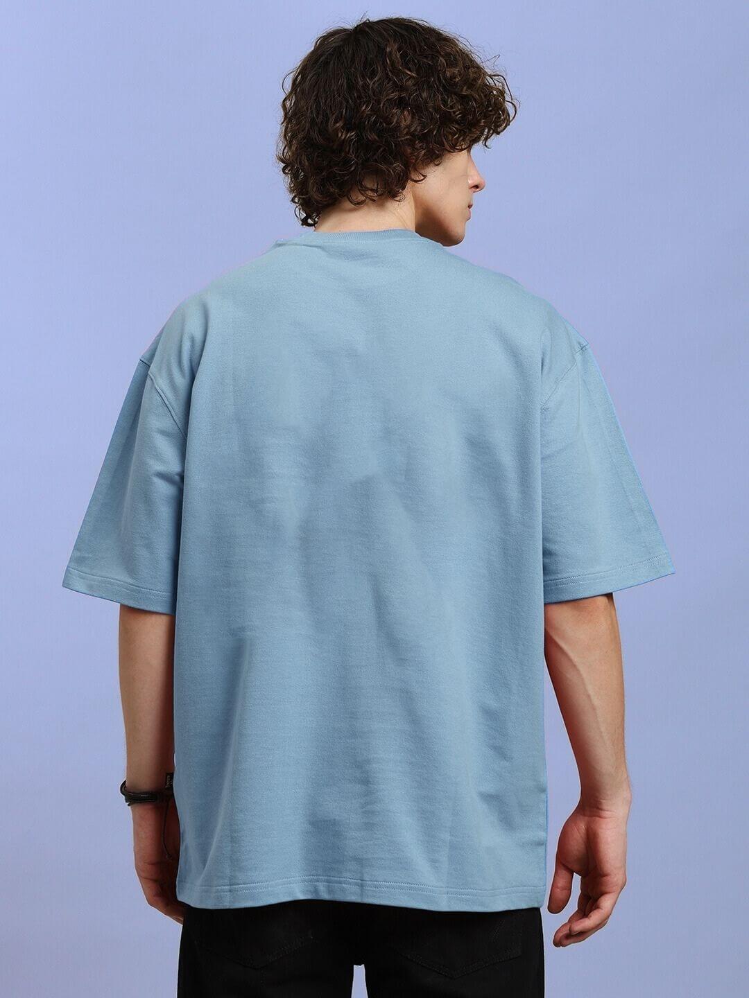 Back view of DEMON PRINTED OVER-SIZED T-SHIRT LIGHT BLUE on model, highlighting the relaxed fit and light blue color.