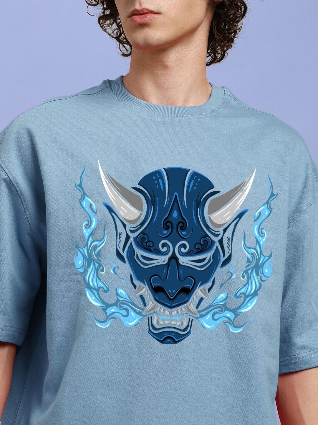 Model wearing DEMON PRINTED OVER-SIZED T-SHIRT LIGHT BLUE with striking demon graphic in blue hues.