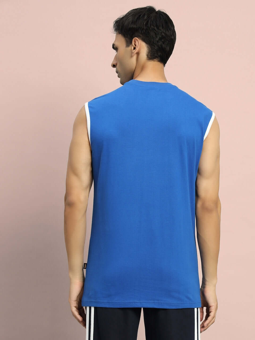 Back view of a model wearing the Desire Gym T-Shirt in royal blue, showcasing sleeveless design and premium fabric quality.