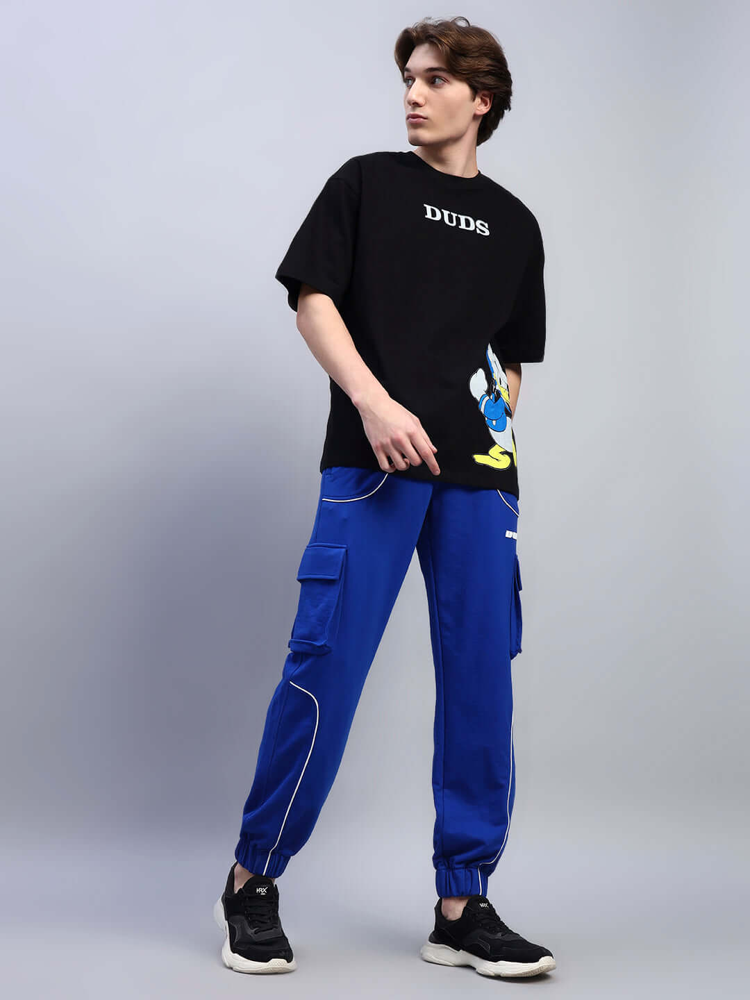 Alt Tag: Person wearing DEVENO RELAXED-FIT JOGGERS BLUE styled with a casual streetwear look.