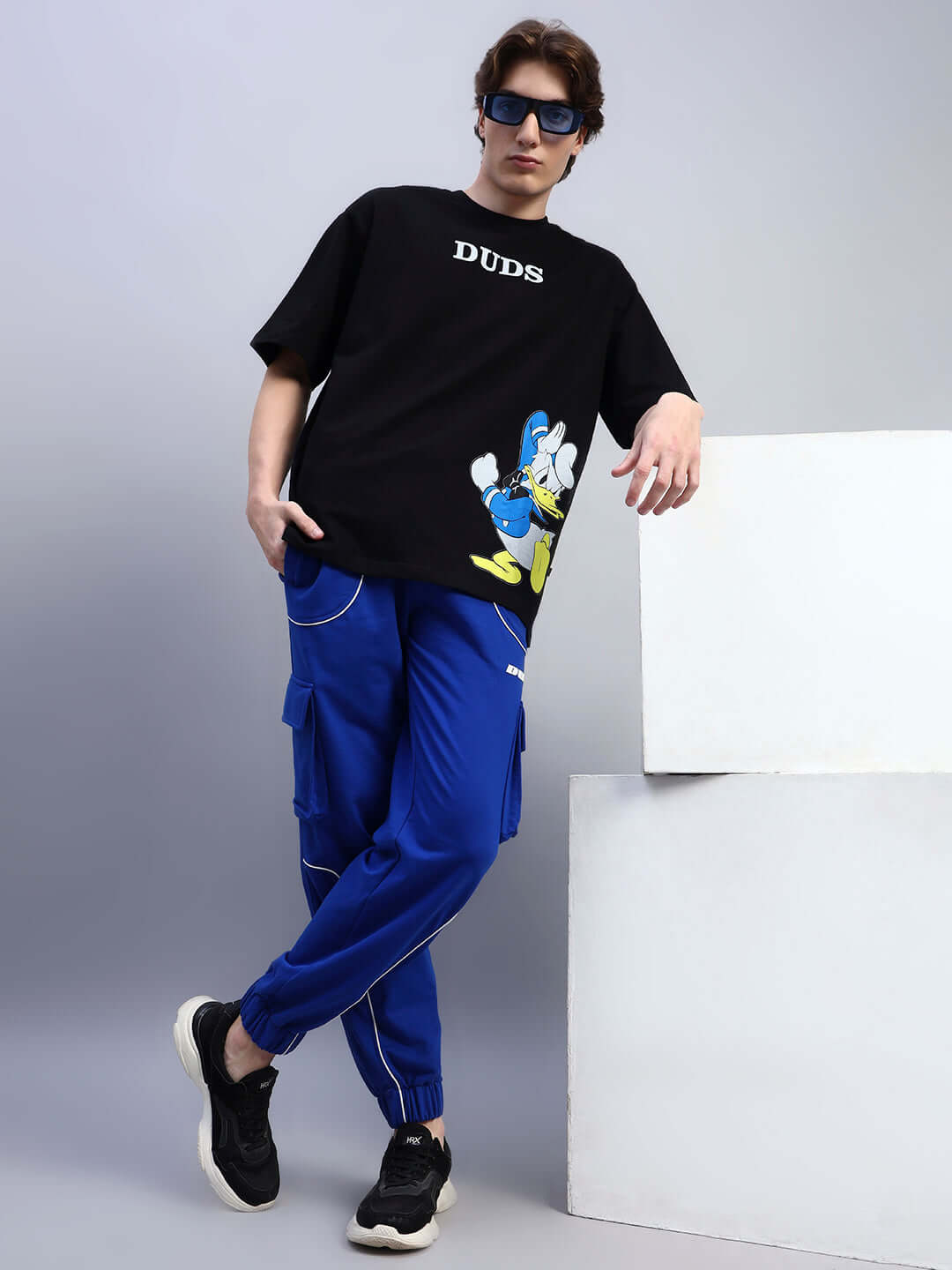 Fashion model wearing DEVENO RELAXED-FIT JOGGERS BLUE in a casual urban setting.