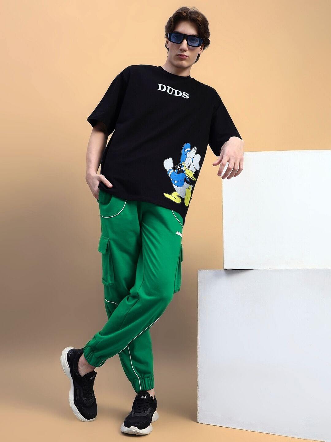 Model wearing DEVENO RELAXED-FIT JOGGERS GREEN with casual black t-shirt and sneakers.