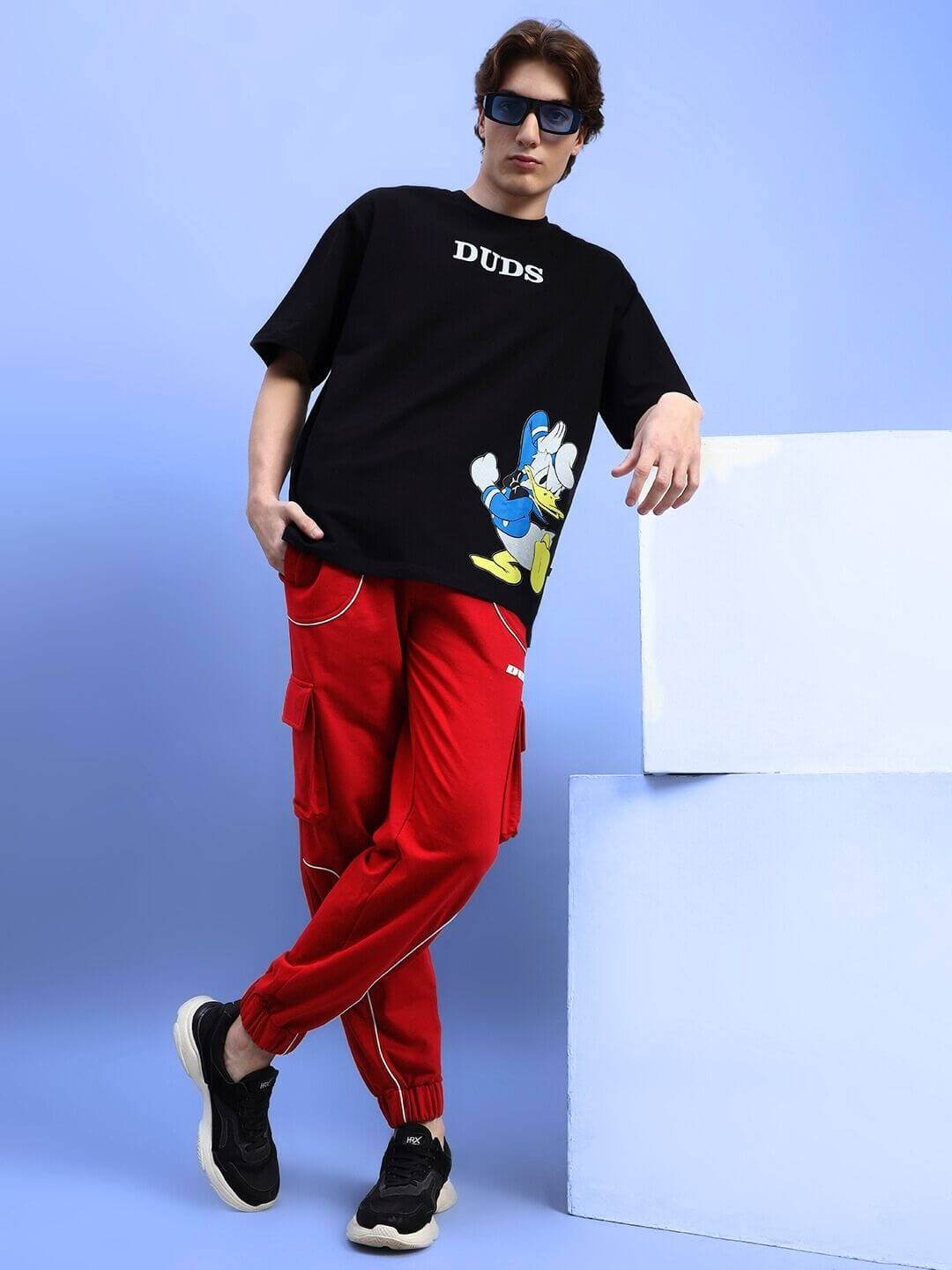 Model wearing DEVENO RELAXED-FIT JOGGERS RED with a graphic tee, showing stylish and comfortable cotton blend joggers in bold red.