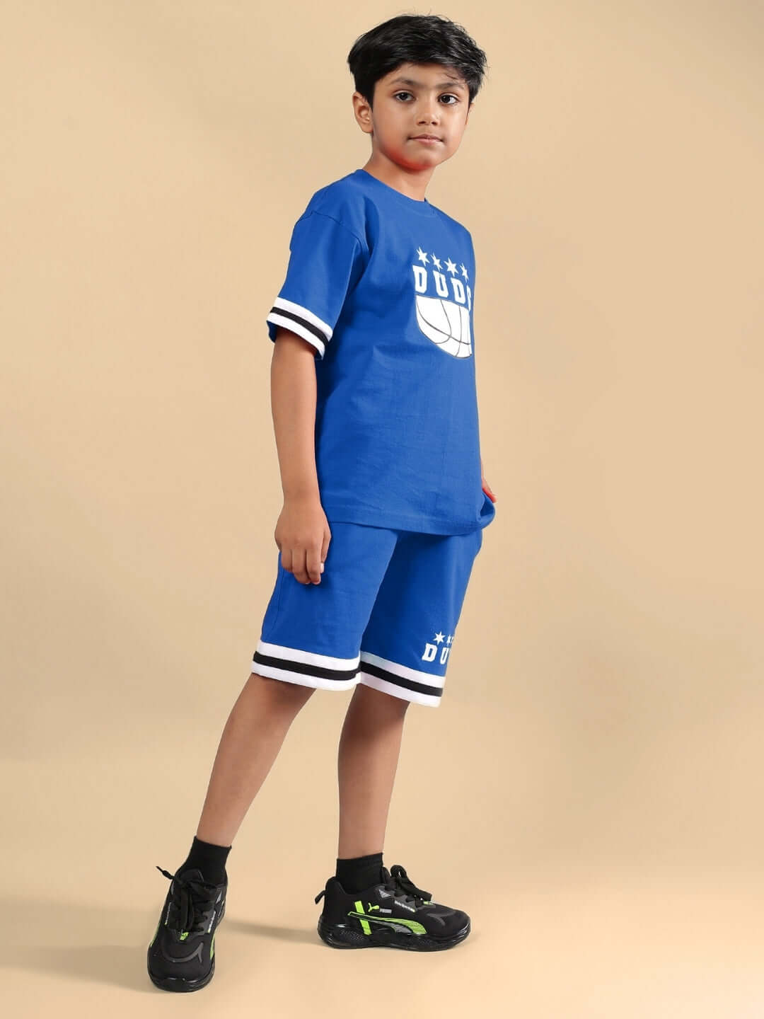 A child wearing the DIGGIN CO-ORD FOR BOYS & GIRLS BLUE outfit, featuring a stylish blue top and shorts with black shoes on a neutral background.