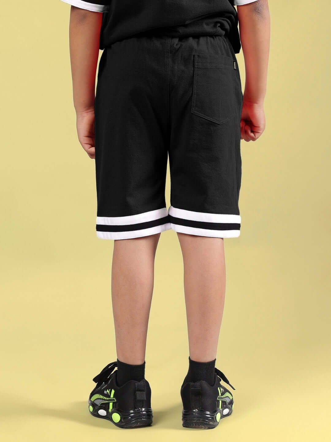 Child wearing DIGGIN SHORTS FOR BOYS & GIRLS BLACK with white trim, made to order by DUDS. Custom fit available for prepaid orders.