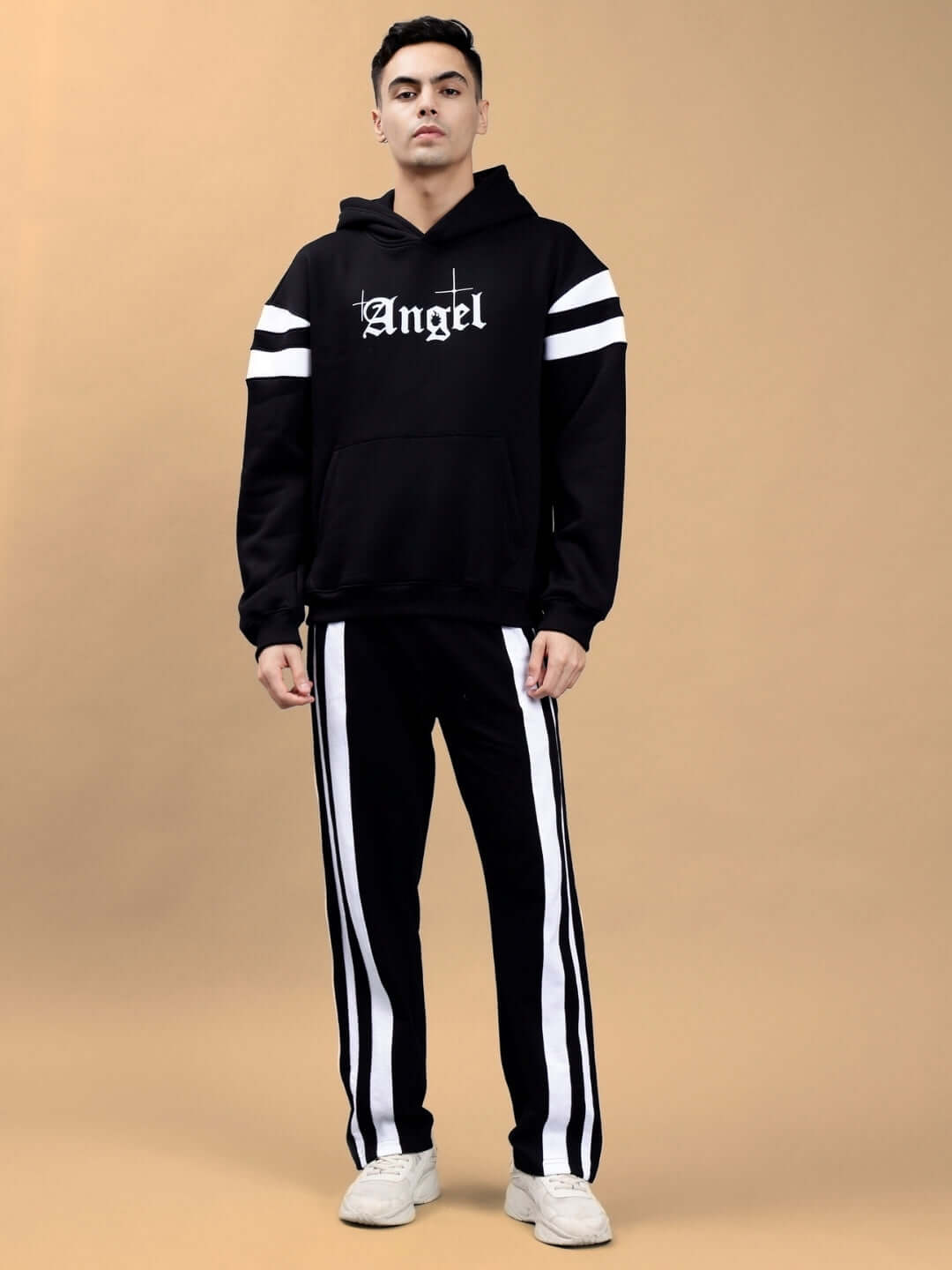 Model wearing black Divine Spirit oversized hoodie with colorblock design and 'Angel' lettering, paired with black and white striped pants.
