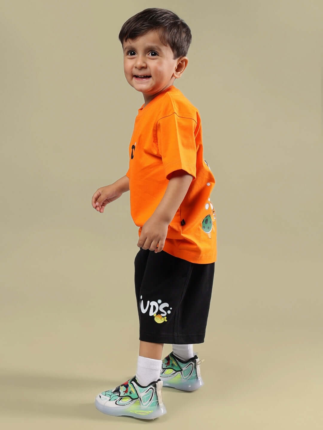 Child wearing DIVING BEAR CO-ORD FOR BOYS & GIRLS ORANGE-BLACK outfit, featuring a vibrant orange T-shirt and black shorts, stylish and playful fashion.