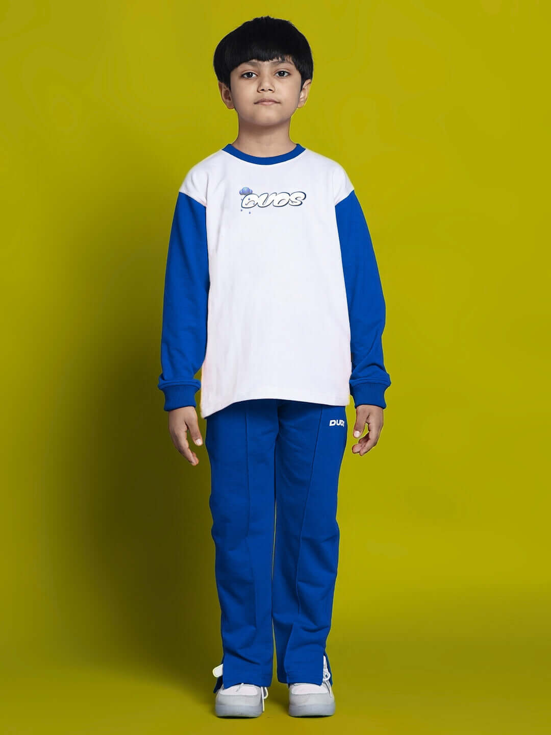 Child wearing DORAEMON CO-ORD SET FOR BOYS GIRLS WHITE BLUE, featuring a white and blue t-shirt and matching pants, with a cheerful expression.