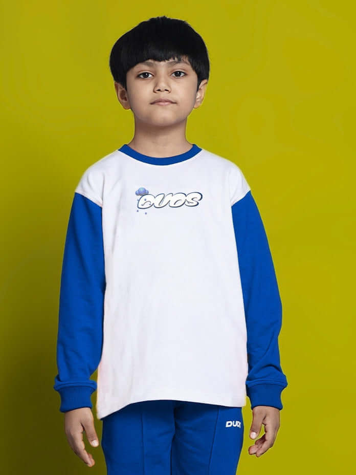 Child wearing a DORAEMON SWEATSHIRT FOR BOYS GIRLS WHITE BLUE with cartoon print and blue sleeves.