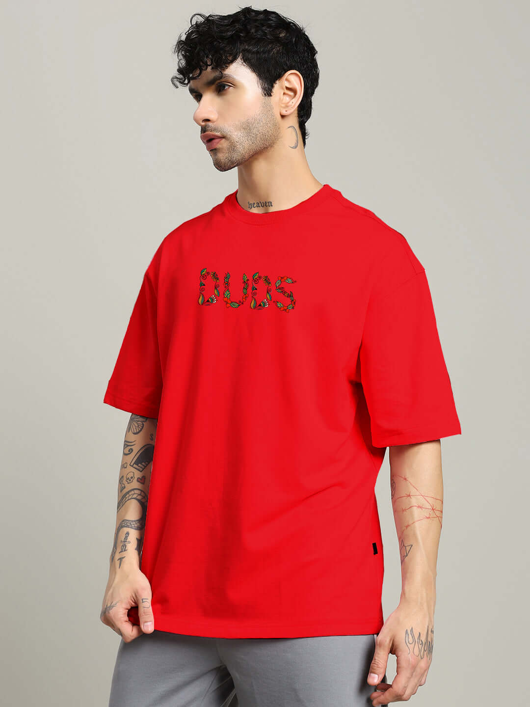 Man wearing red oversized t-shirt with 'BUBS' design, made from premium cotton and elastane blend from Color By Colours.
