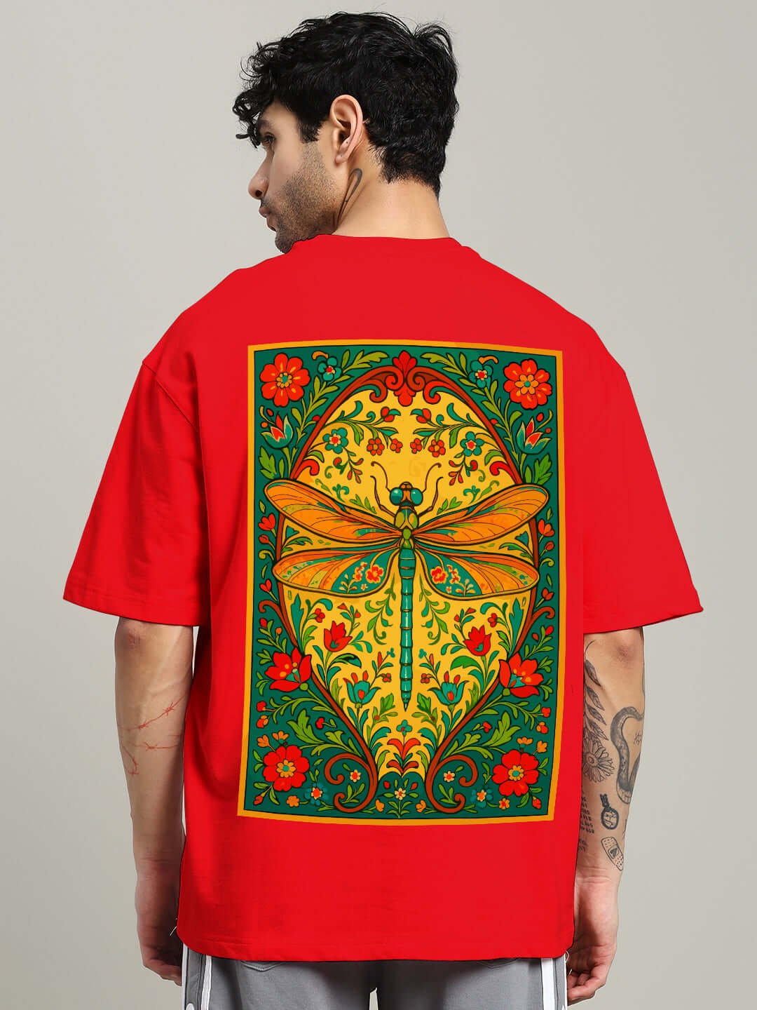 Back view of person wearing DRAGONFLY OVERSIZED T-SHIRT RED with a colorful dragonfly design.