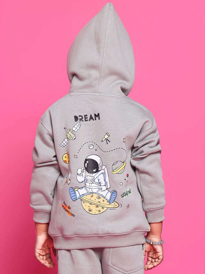 Alt Tag: Child wearing grey DREAM oversized hoodie with space design.