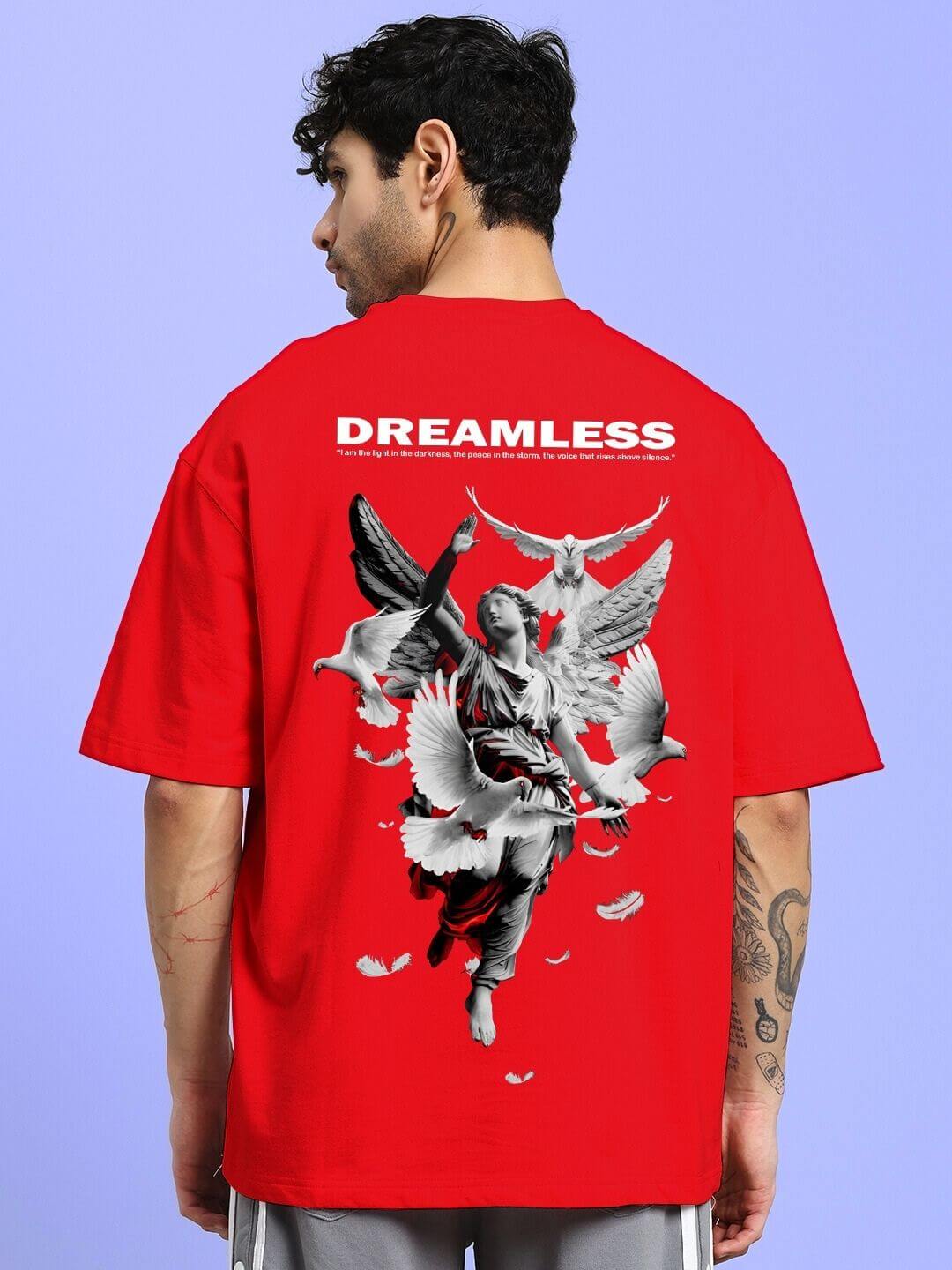Back view of model wearing DREAMLESS OVER-SIZED T-SHIRT RED with printed graphic, showcasing bold streetwear style.