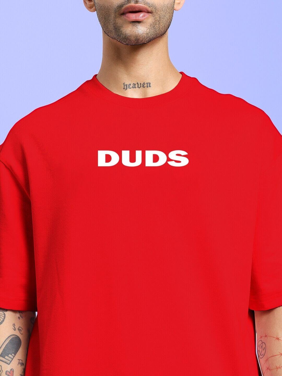 DREAMLESS OVER-SIZED T-SHIRT RED featuring bold white 'DUDS' text on chest, worn by a model with tattoos, streetwear fashion style.