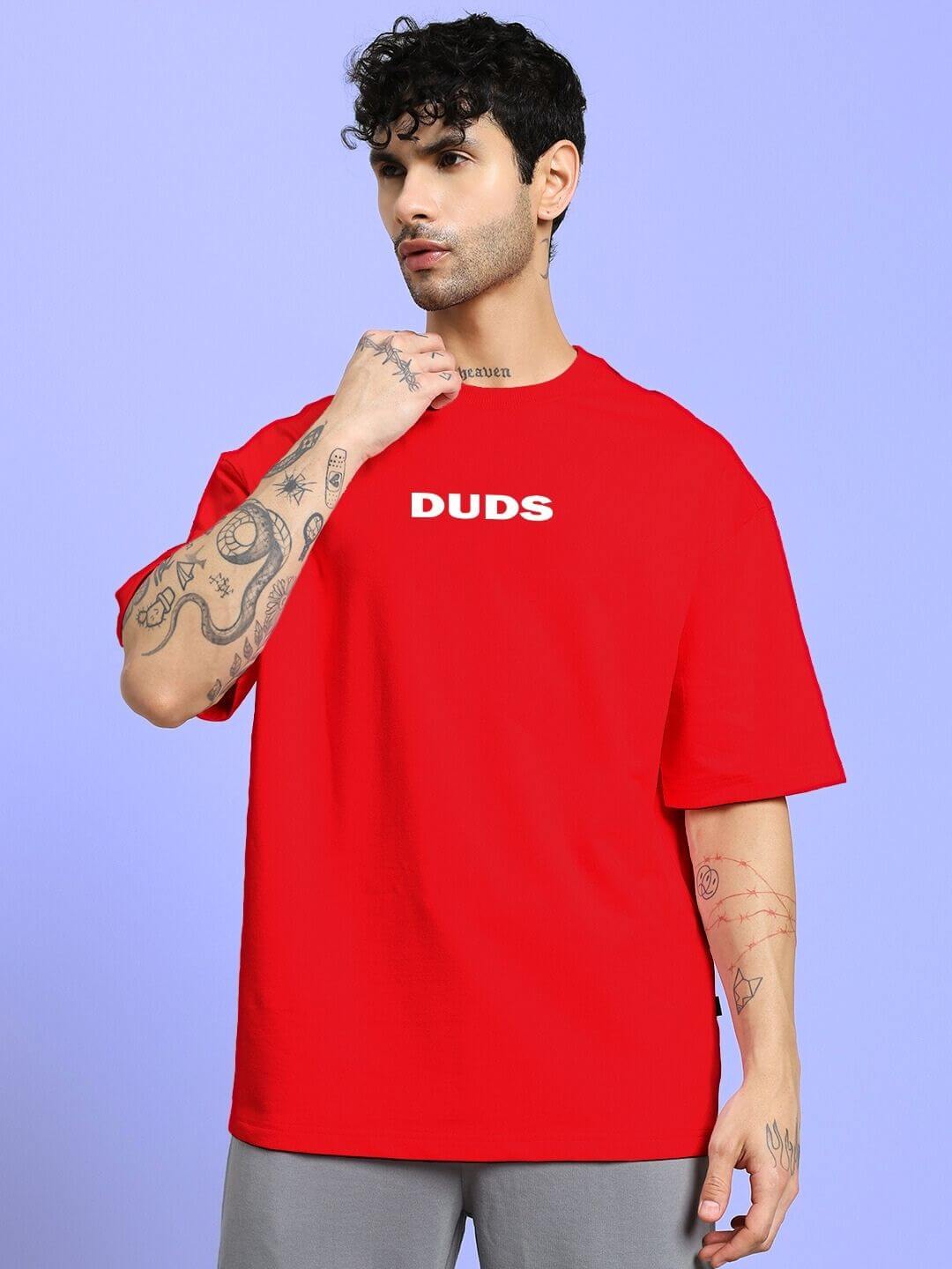 Man wearing DREAMLESS OVER-SIZED T-SHIRT RED with 'DUDS' logo, demonstrating bold streetwear style.