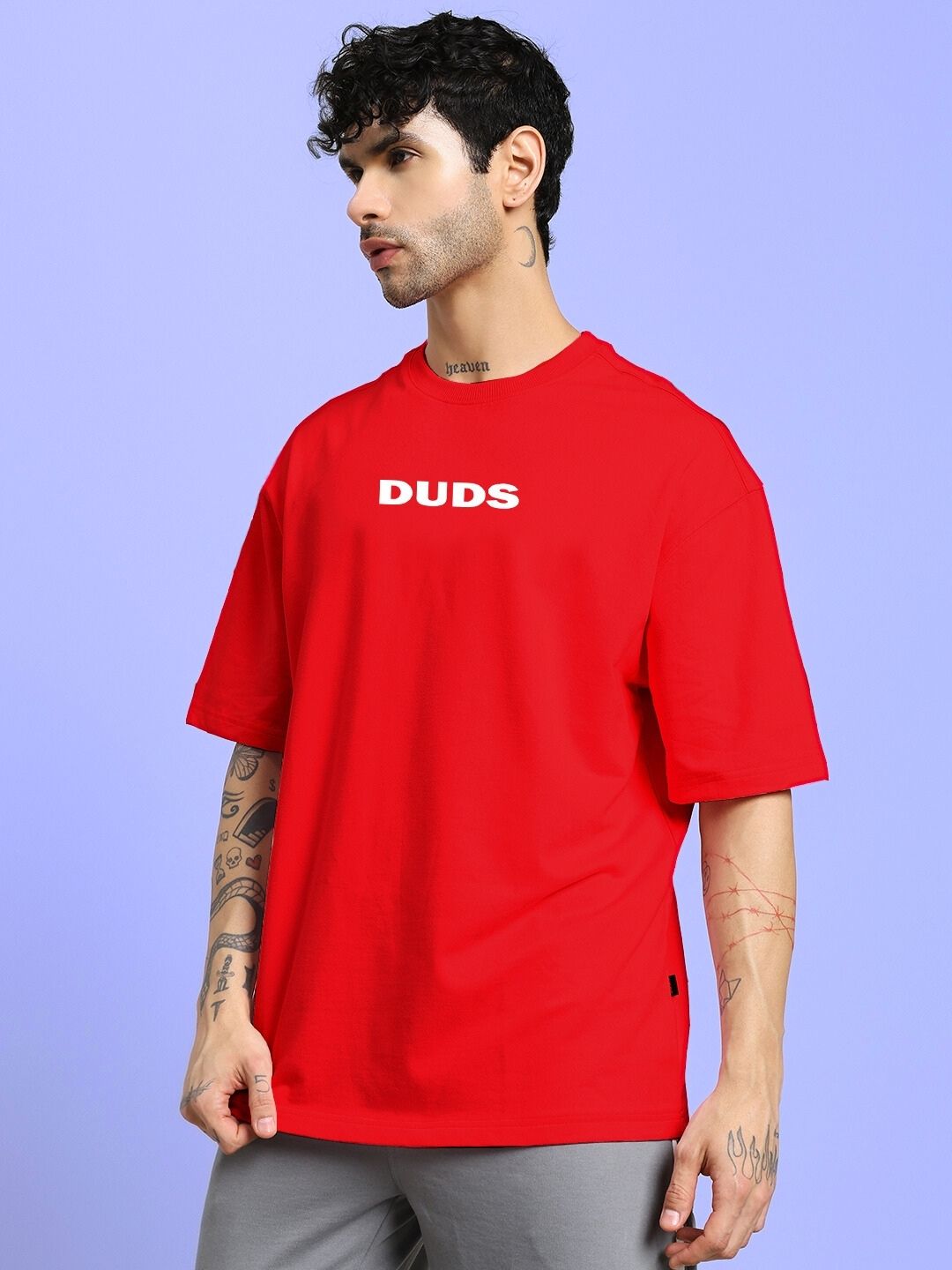 Man wearing DREAMLESS OVER-SIZED T-SHIRT RED with 'DUDS' logo, showcasing comfortable casual fashion for everyday wear.
