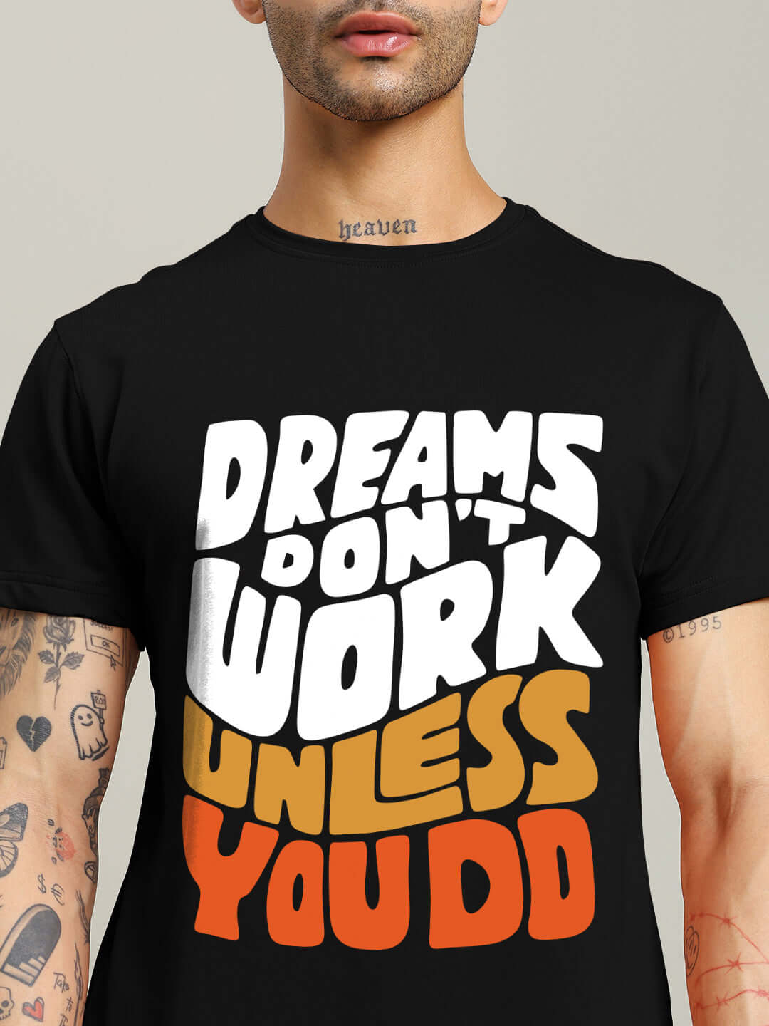 Man wearing DREAMS REGULAR FIT T-SHIRT BLACK with motivational quote 'Dreams Don't Work Unless You Do' in bold letters.