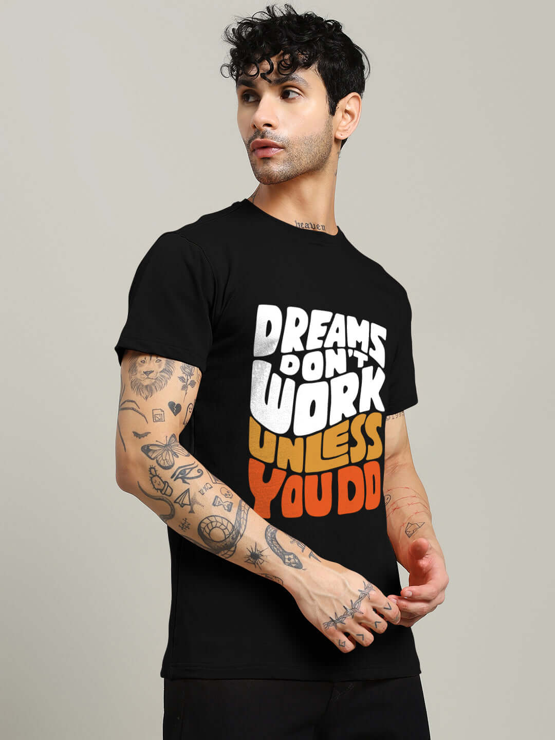 Model wearing DREAMS REGULAR FIT T-SHIRT BLACK with motivational text, showcasing comfort and style.