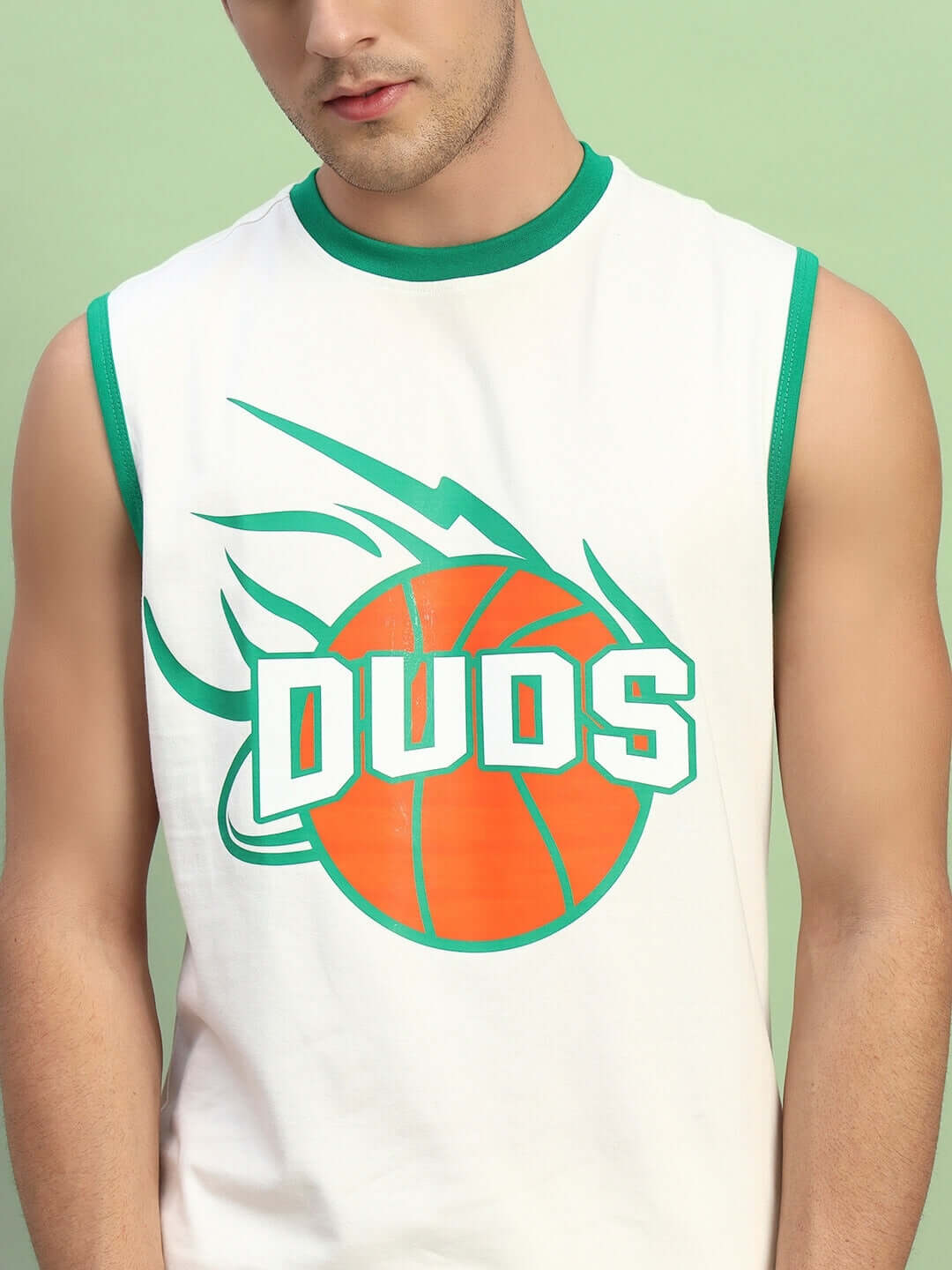 Man wearing DRIBBLE CO-ORD SET SLEEVELESS OFF WHITE sporty top with green trim and basketball graphic.