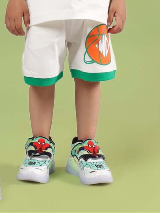 Child wearing DRIBBLE SHORTS FOR BOYS & GIRLS OFF WHITE with vibrant trim