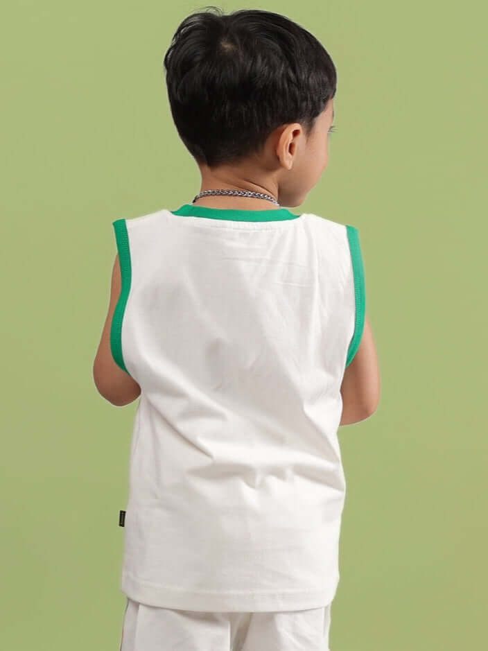Back view of child wearing a DRIBBLE T-SHIRT FOR BOYS & GIRLS OFF WHITE with green trim in a casual setting.
