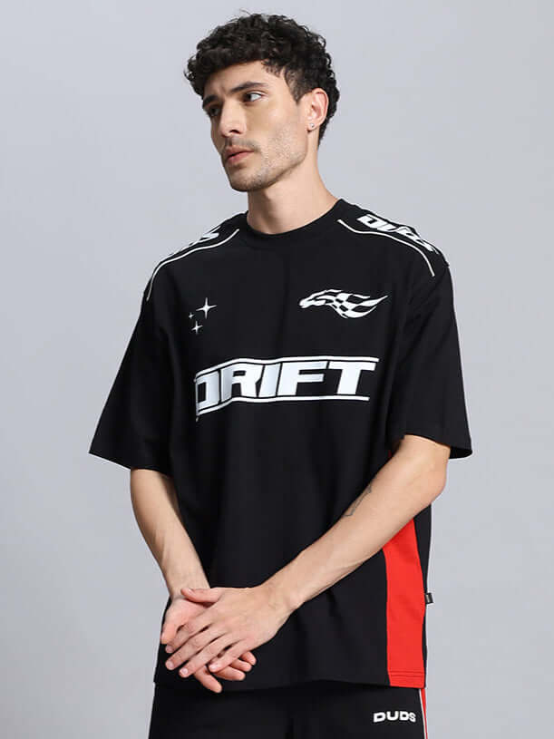 Man wearing black DRIFT over-sized t-shirt with graphic print, available with custom fit option for prepaid orders, designed by DUDS.
