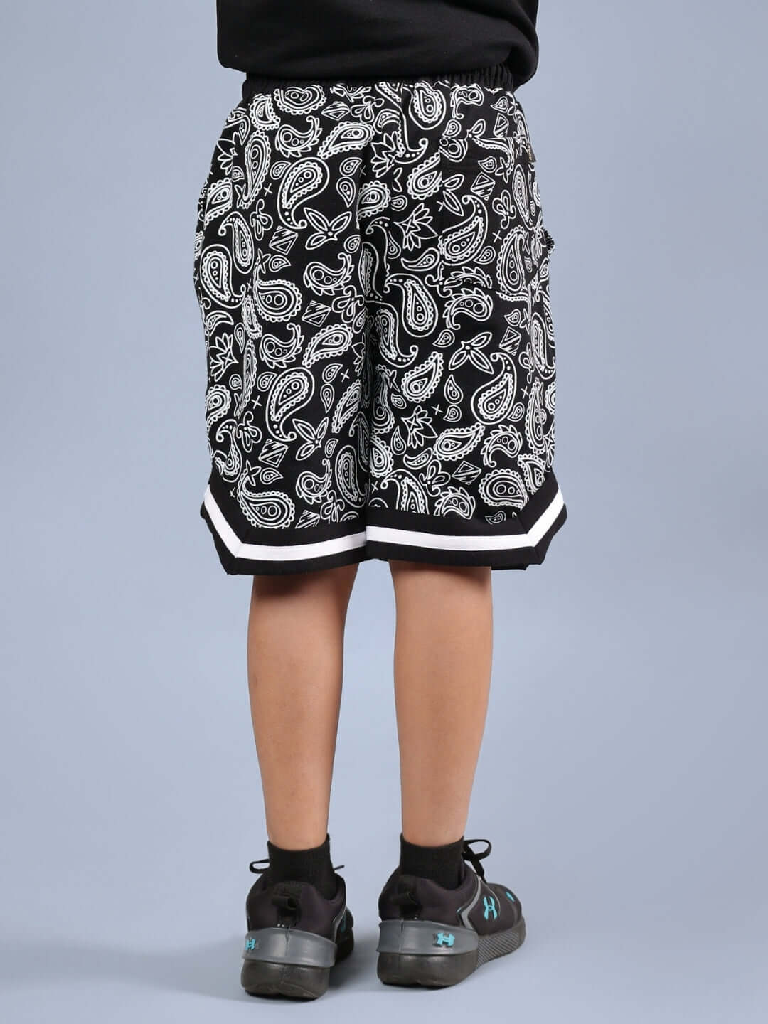 Back view of DRIZZLE SHORTS FOR BOYS & GIRLS BLACK with paisley pattern, suitable for both genders. Custom fit option available for tailored sizing.