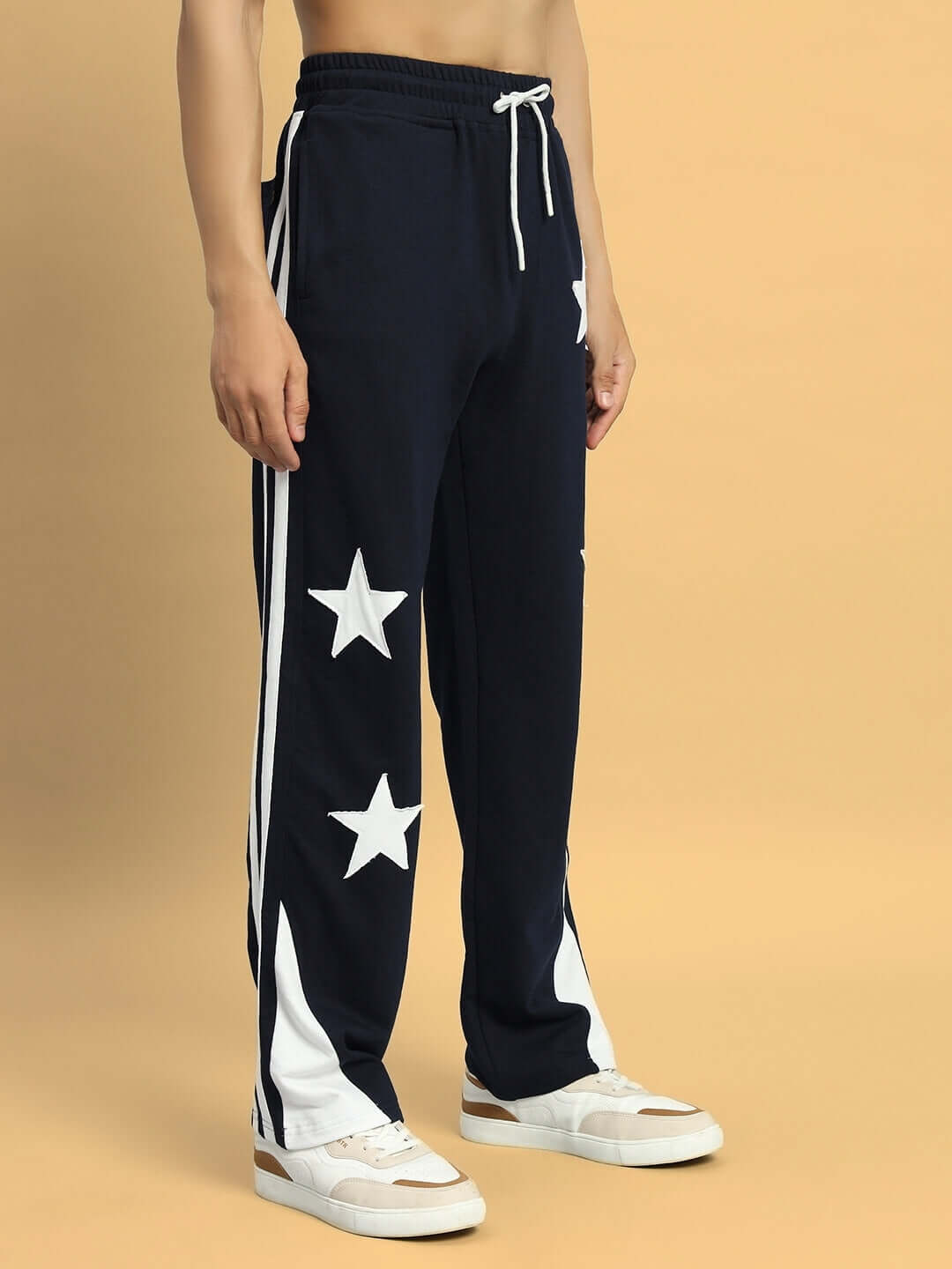 Model wearing navy blue DROOP Relaxed Joggers with white star pattern, featuring custom fit option and experienced tailoring by DUDS.