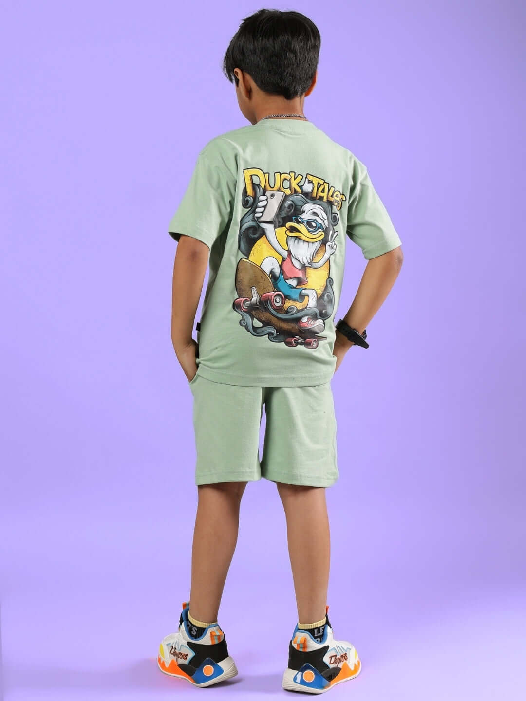 Child wearing DUCK TALES CO-ORD FOR BOYS & GIRLS NYANZA GREEN against a purple background