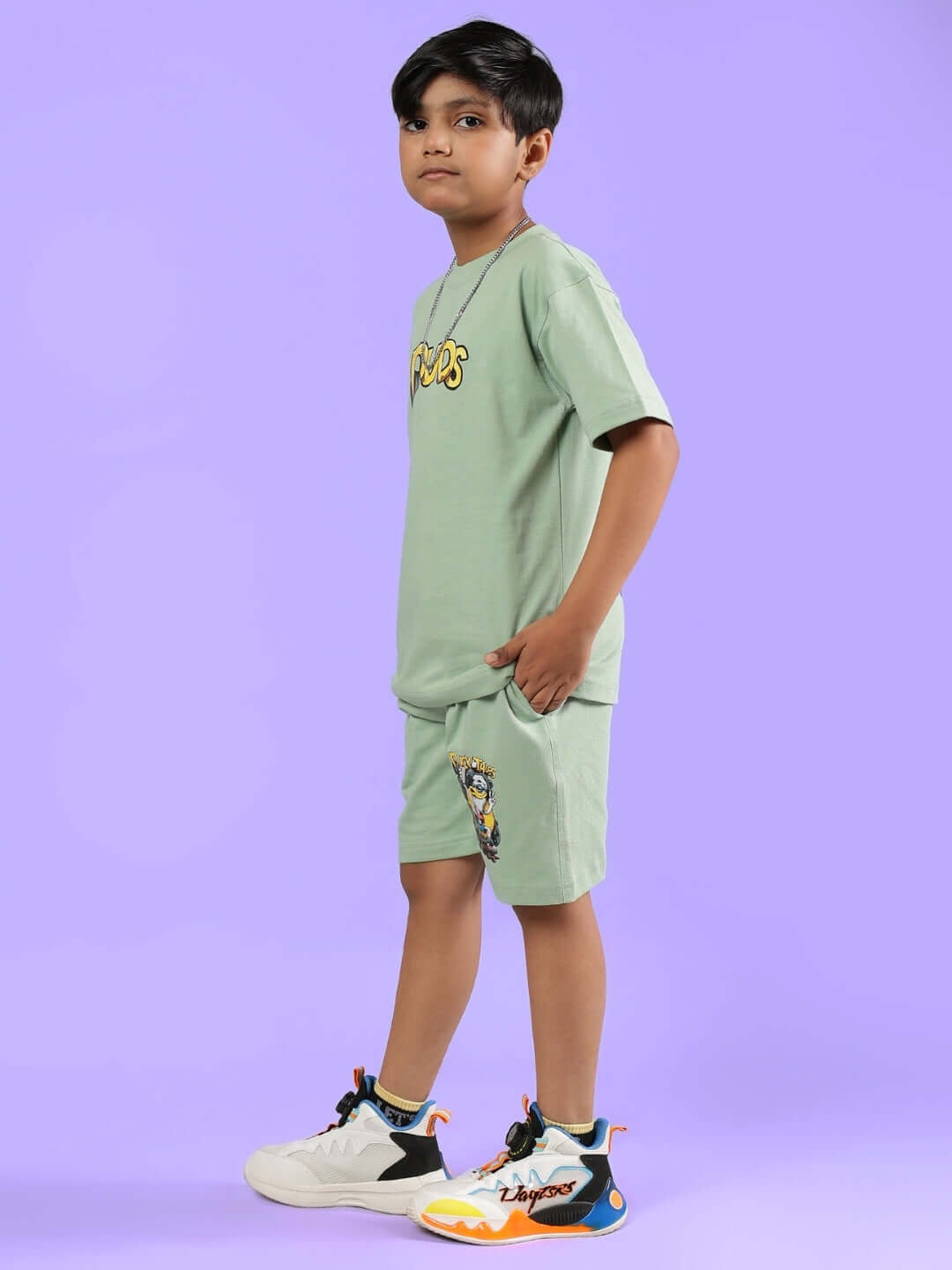 Child wearing DUCK TALES CO-ORD FOR BOYS & GIRLS NYANZA GREEN against a purple background.