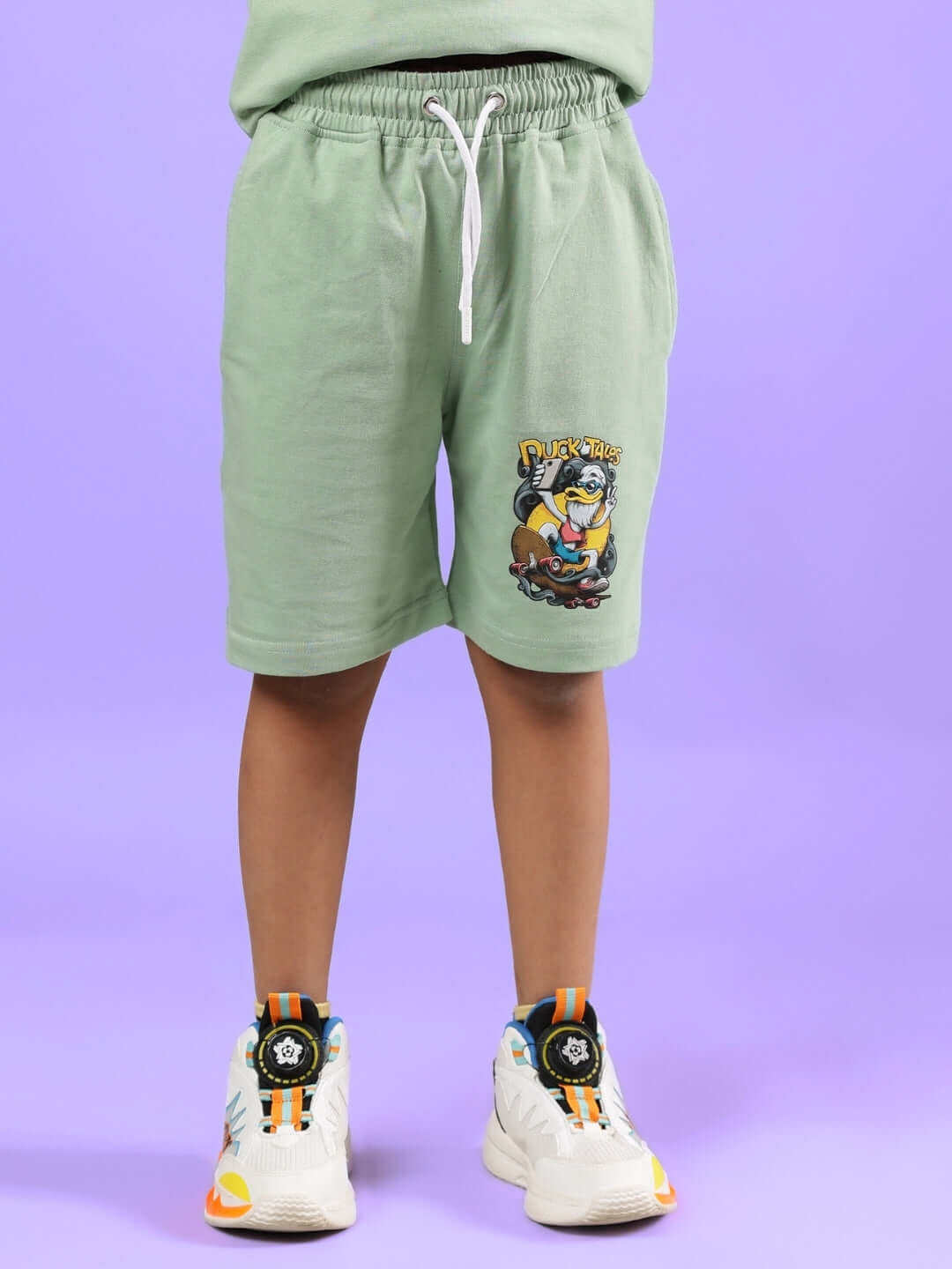 Child wearing Duck Tales Shorts for Boys & Girls Nyanza Green with cartoon design and drawstring waist.