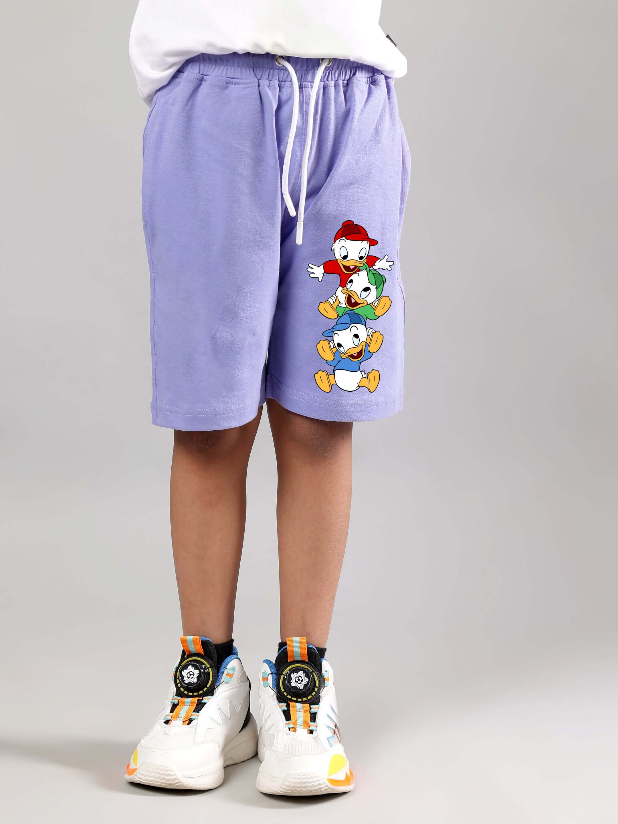 DUCK PLAY SHORTS FOR BOYS GIRLS LAVENDER with playful duck design, shown in lavender on child model wearing sneakers.