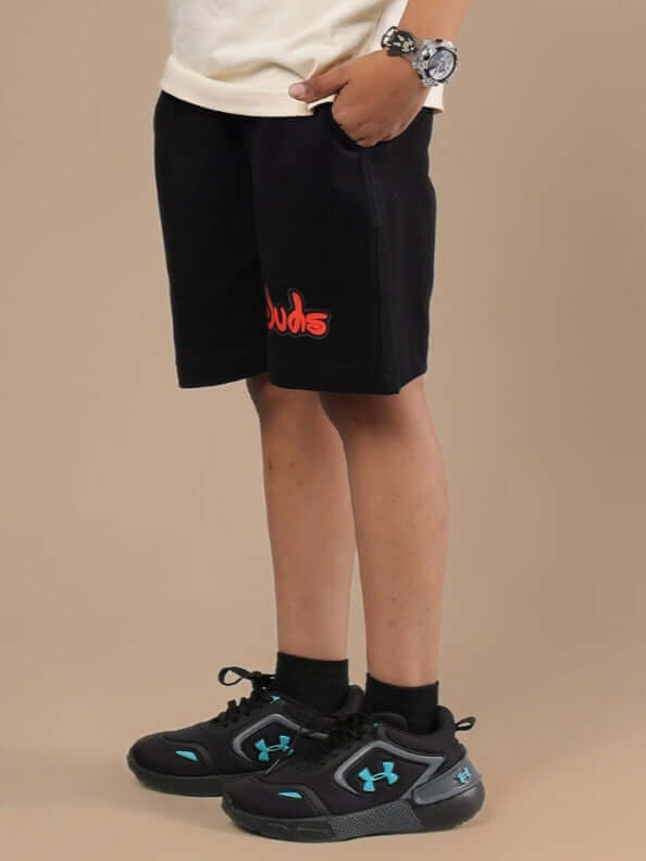 Child wearing DUDS MOUSE SHORTS FOR BOYS & GIRLS BLACK with sneakers.