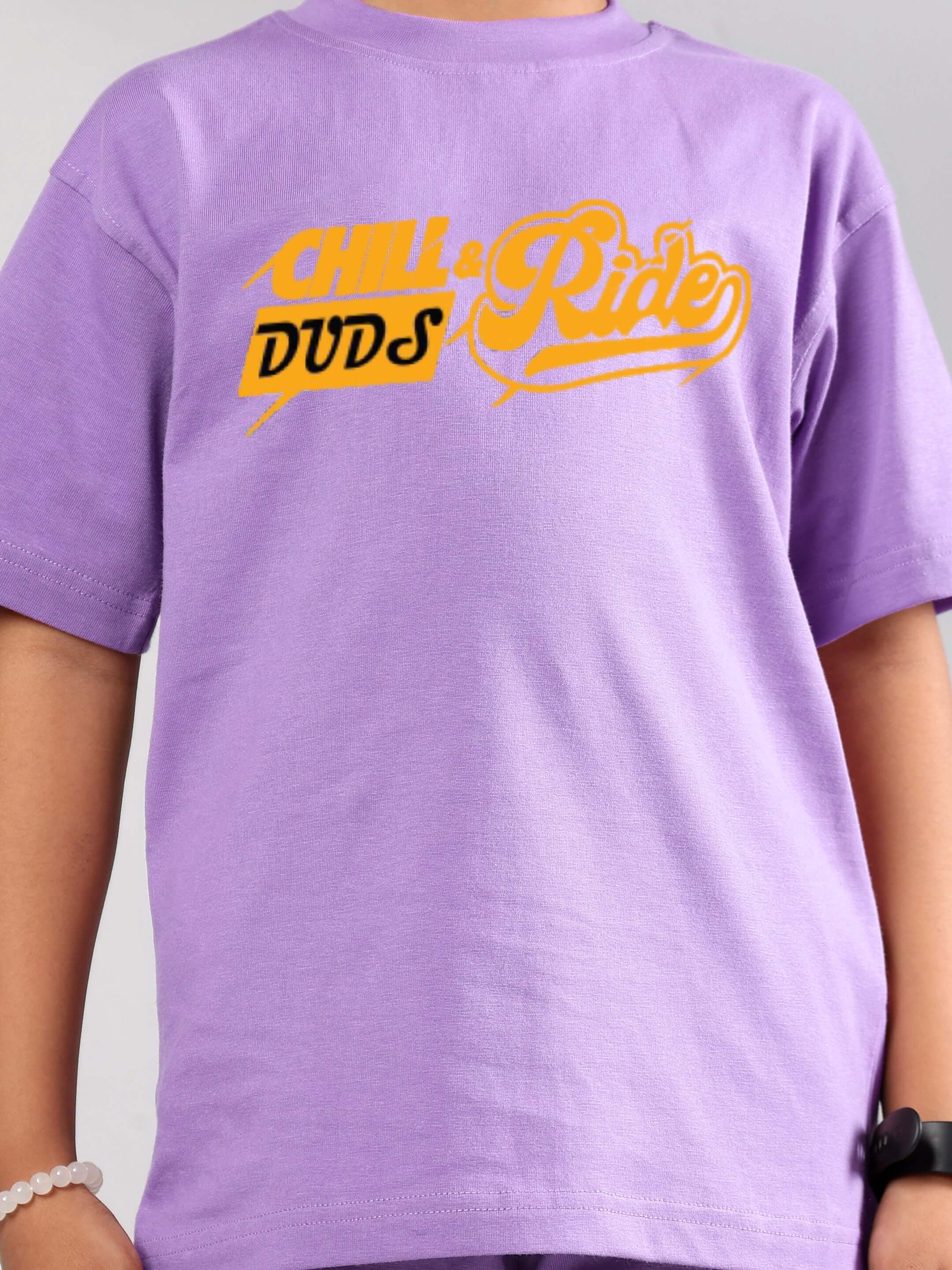 Child wearing DUDS CHILL RIDE CO-ORD FOR BOYS GIRLS LAVENDER t-shirt with yellow graphic print.