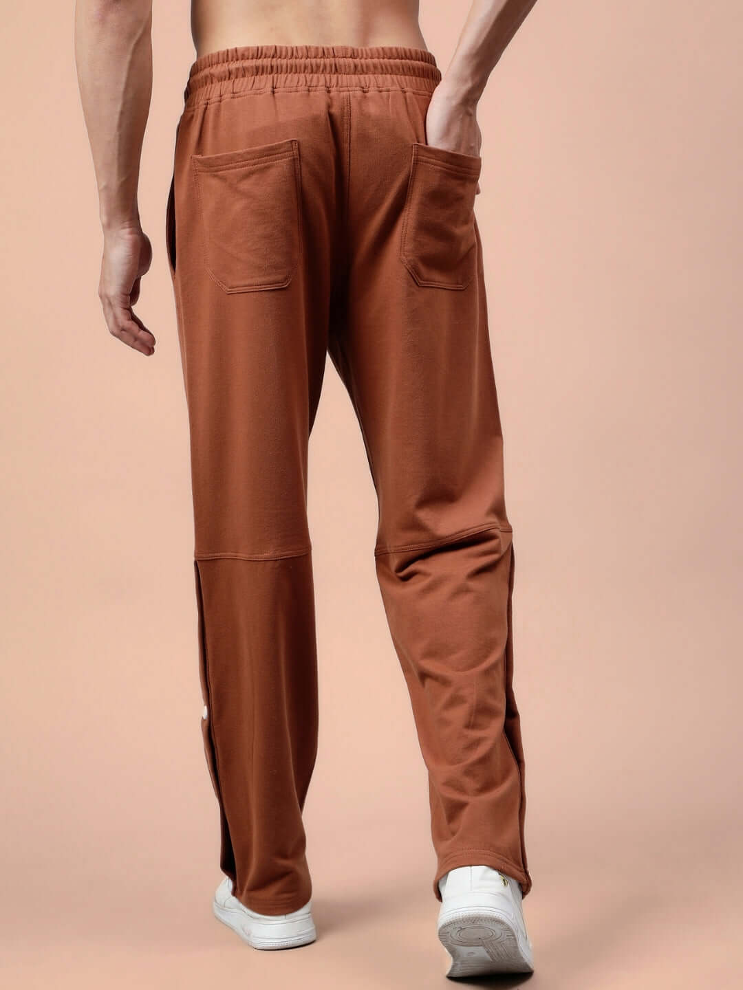 Back view of DUDS Racer Joggers in brown, featuring tailored fit and dual rear pockets, worn by a model showcasing comfortable design.