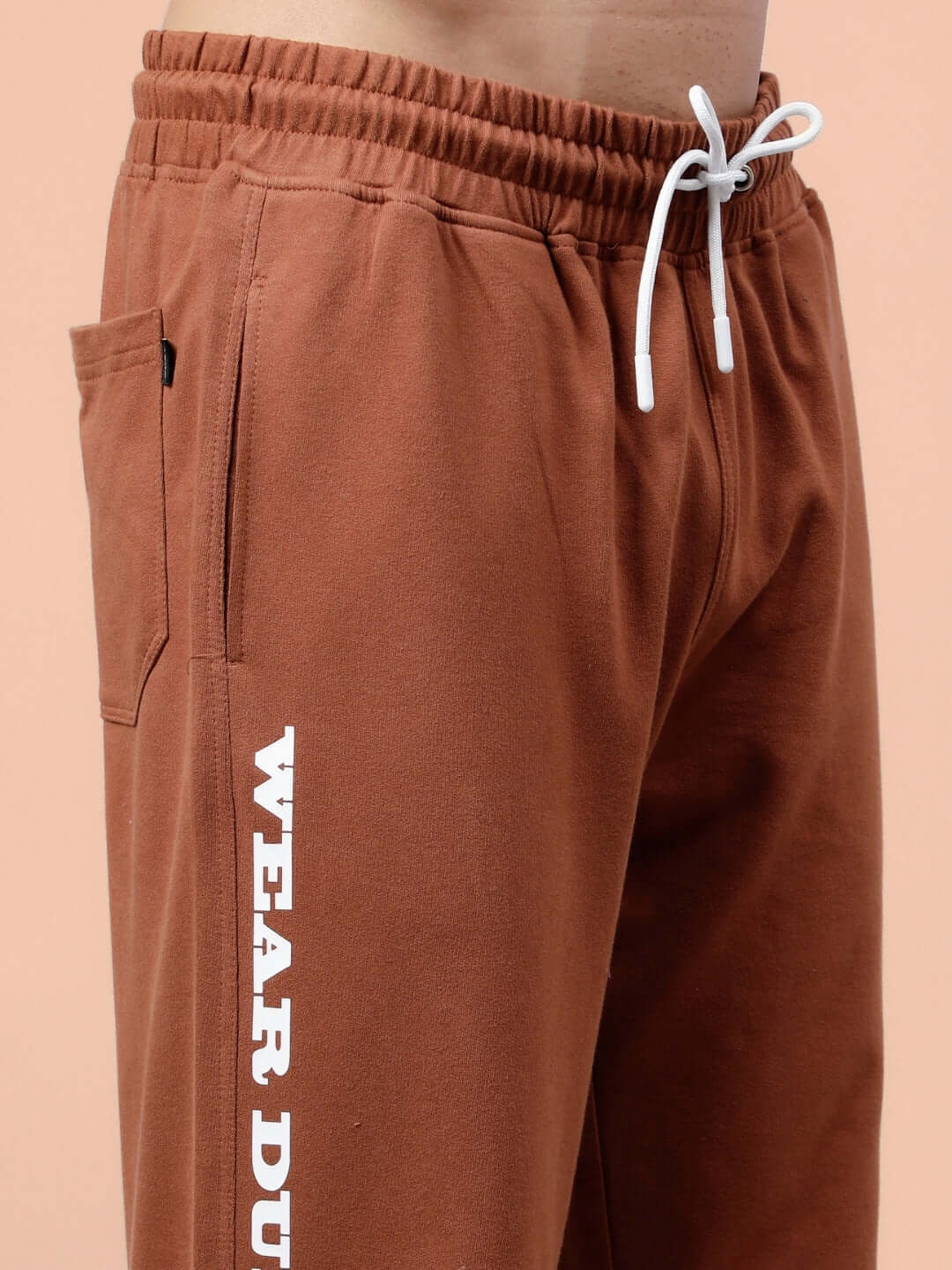 Side view of DUDS Racer Joggers in brown with drawstring and pocket detail, showcasing made-to-order craftsmanship.