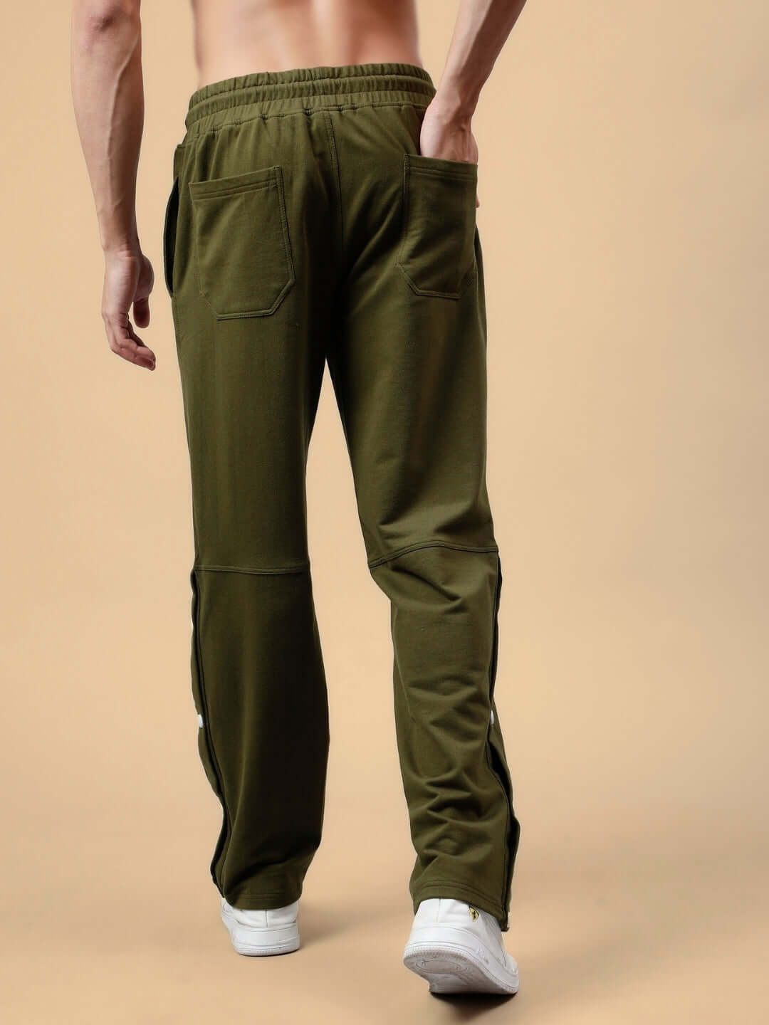 Man wearing DUDS Racer Joggers in olive green, showcasing back pockets and comfortable fit, ideal for casual or sporty look.