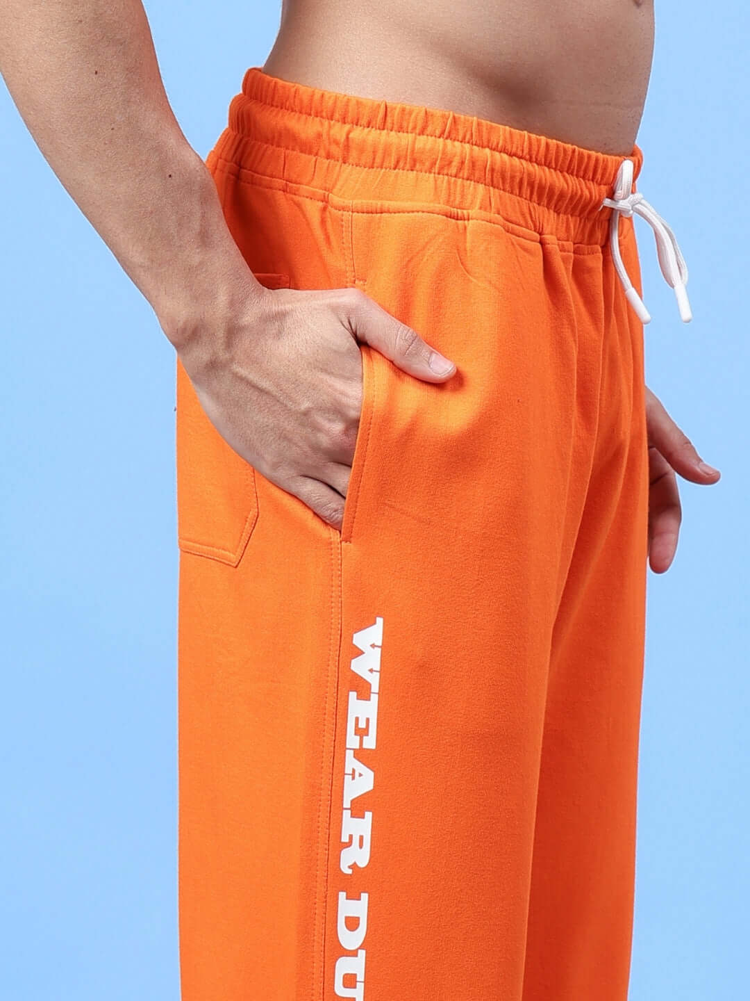 Close-up of DUDS Racer Joggers in orange, featuring a comfortable fit and stylish design. Perfect for custom and prepaid orders.