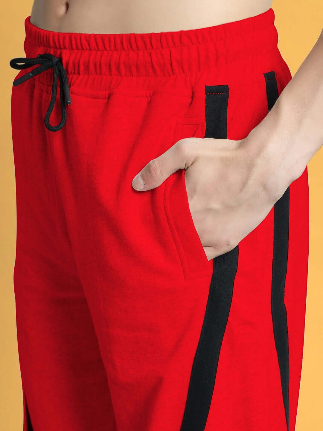 Close-up of DUDS FRAME red joggers with black accents, featuring adjustable waistband and comfortable fit, ideal for custom tailoring.